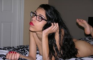 Inked brunette solo girl Karmen Karma showing off thong adorned ass